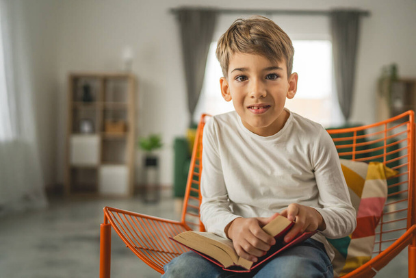 Один хлопчик кавказька дитина сім років дитина в кімнаті вдома читати книгу - Фото, зображення