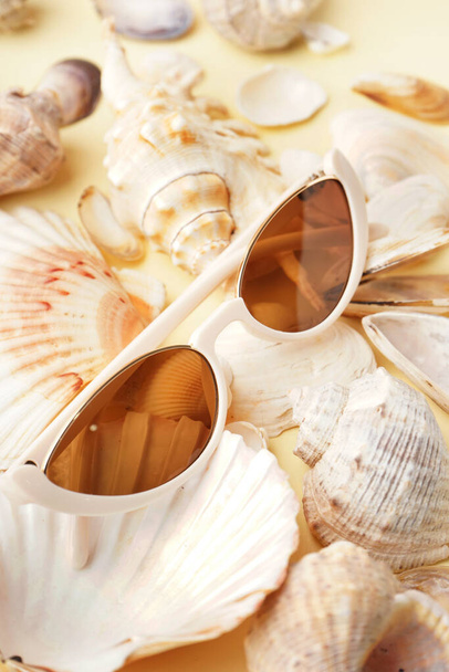 Gafas de sol blancas modernas con conchas marinas sobre fondo claro - Foto, imagen