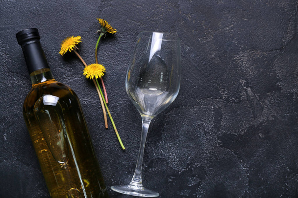 Lahvička a sklenice pampeliškového vína na černém pozadí - Fotografie, Obrázek