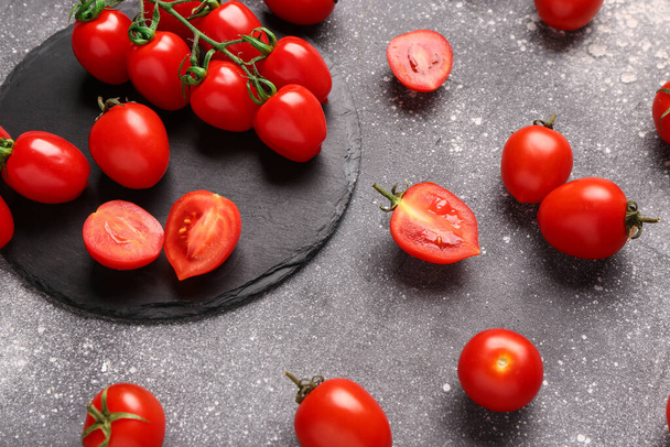 Tablero con tomates cherry frescos sobre fondo gris - Foto, Imagen