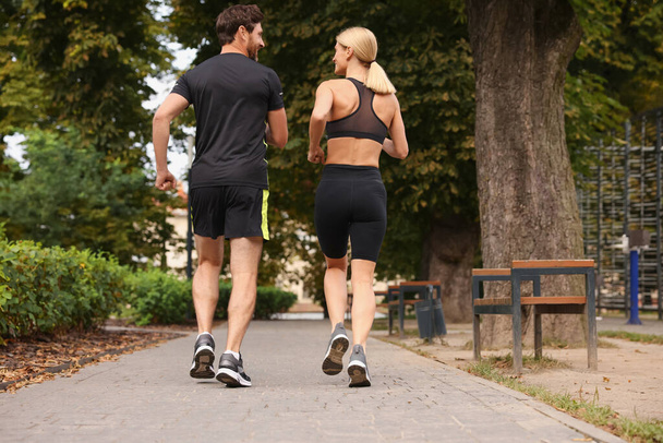Healthy lifestyle. Happy couple running in park, back view - Foto, imagen