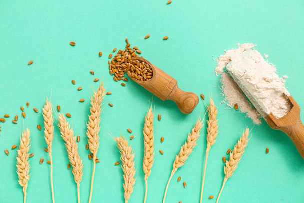 Escovas de madeira com farinha de trigo e grãos em fundo turquesa - Foto, Imagem