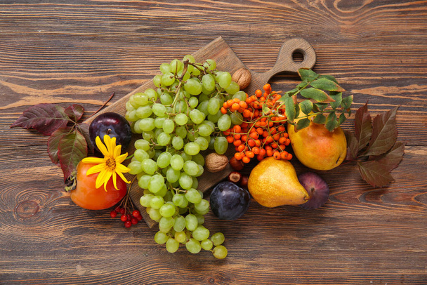 Доска из различных свежих фруктов на деревянном фоне - Фото, изображение