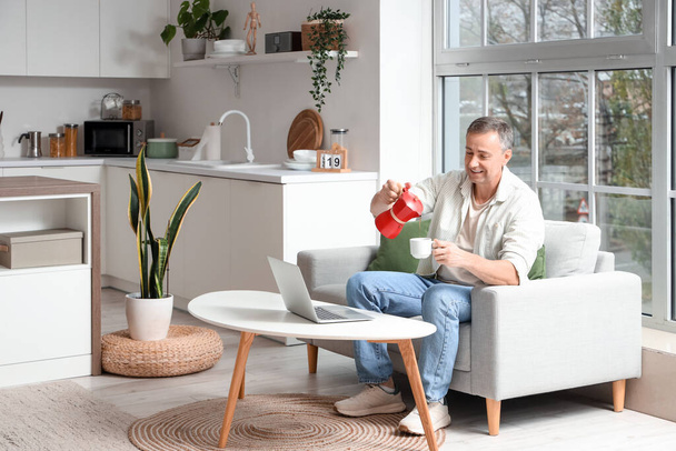 Felnőtt férfi öntés eszpresszó gejzír kávéfőző csészébe a konyhában - Fotó, kép