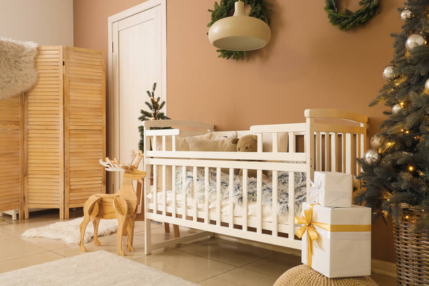 Wnętrze sypialni z łóżeczkiem niemowlęcym i choinkami - Zdjęcie, obraz