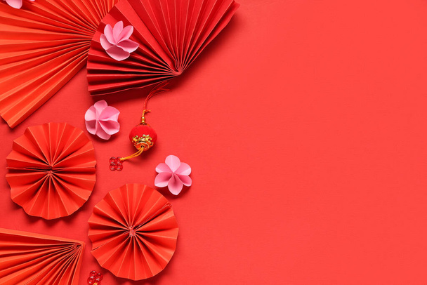 Ventilatori con bellissimi fiori e lanterna su sfondo rosso. Celebrazione del Capodanno cinese - Foto, immagini