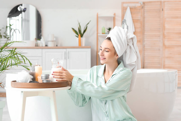 Beautiful woman after shower with jug of milk in bathroom - Photo, Image