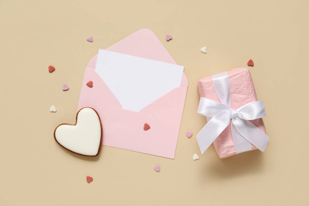 Biscuit en forme de coeur avec enveloppe et boîte cadeau sur fond jaune. Fête de la Saint-Valentin - Photo, image