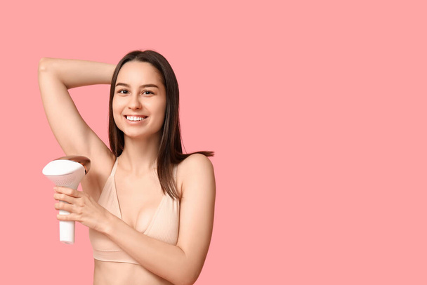 Mujer joven feliz con fotoepiléptica moderna sobre fondo rosa - Foto, imagen