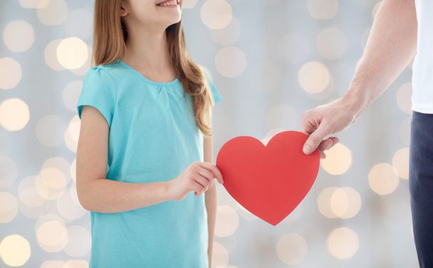 close up of girl and male hand holding red heart - Fotografie, Obrázek
