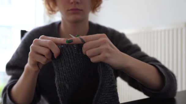 Nuori nainen neuloo villatuotteita. kädet tunnistamaton nuori nainen manikyyri neulonta tuote harmaa villalanka - Materiaali, video