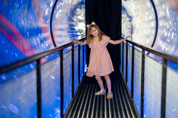 Evreni ve yerçekimini gösteren bir odada bilim müzesini ziyaret eden küçük bir kız. Çocuk eğlencesi ve öğrenme kavramı - Fotoğraf, Görsel