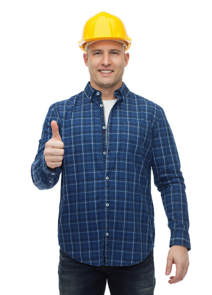 smiling male builder in helmet showing thumbs up - Fotoğraf, Görsel