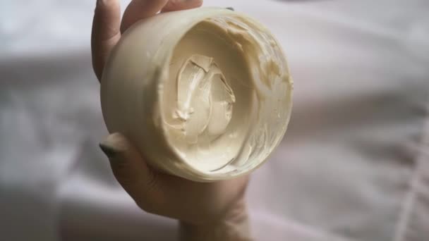 Close-up de um frasco com uma máscara facial nas mãos de um cosmetologista. Conceito de cosméticos de cuidados com a pele. Vídeo vertical - Filmagem, Vídeo