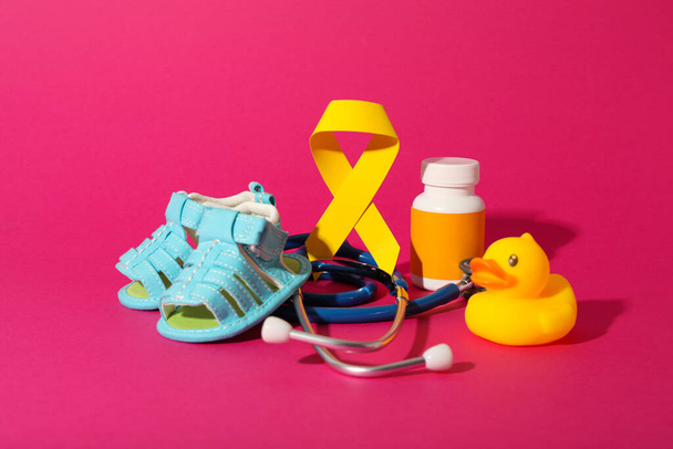Blue children's shoes with a yellow ribbon and a stethoscope - Photo, Image