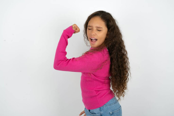 Portrait of funny teenager girl wearing pink sweater shout yeah raise fists hands celebrate victory game competition - Photo, Image