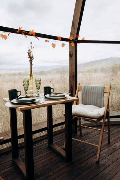 Asztalbeállítás reggelire, ebédre vagy vacsorára. Asztal két beltéri panorámás ablakokkal a természet közepén. Vendéglátás, kávézó, étterem - Fotó, kép