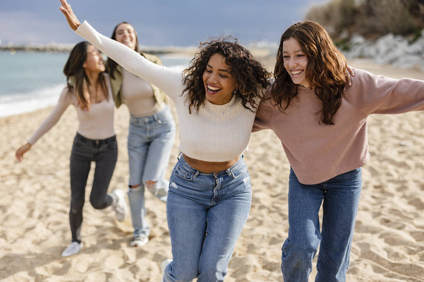 groupe d'amis multiethniques en vacances jouer courir sur la plage - Photo, image