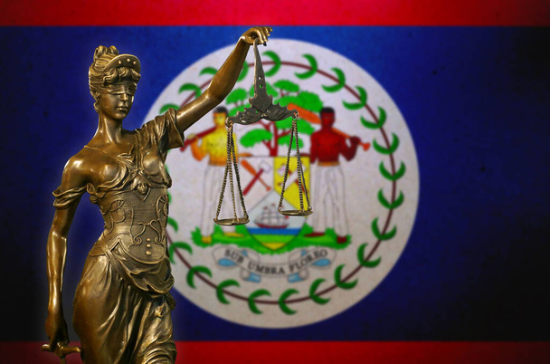 Detailní záběr malé bronzové sošky Lady Justice před vlajkou Belize. - Fotografie, Obrázek