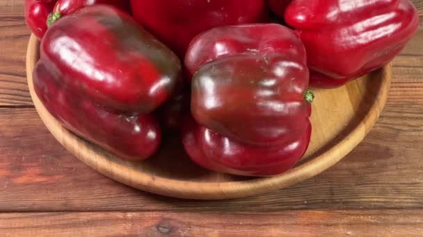 Pimentas vermelhas frescas no prato de madeira na mesa rústica - Filmagem, Vídeo