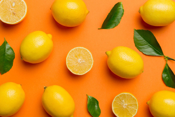Molti limoni freschi maturi come sfondo colorato, vista dall'alto. Elegante sfondo di fette di limone e limone Vista dall'alto piatto lay. - Foto, immagini
