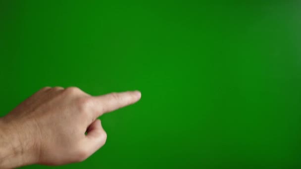 La mano de un hombre sobre un fondo verde se desplaza hacia arriba. Concepto pantalla táctil. - Metraje, vídeo