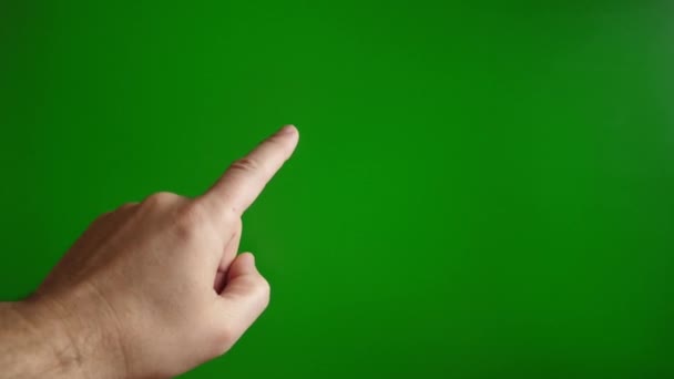 De hand van een man op een groene achtergrond rolt omhoog. Aanraakscherm concept. - Video