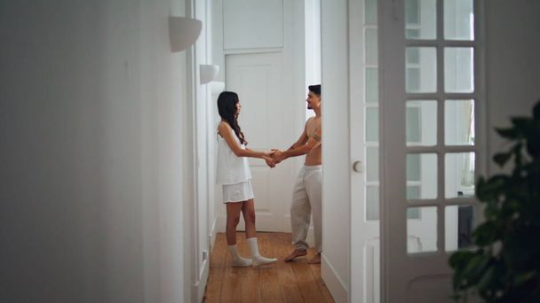 Aşk çifti koridorda sarılıyor. Şehvetli insanlar evlerinde mesafeye bakarlar. Romantik erkek ve kadın balayını birlikte kutluyorlar. Mutlu kız arkadaş kocasına dikkat ettiğini gösteriyor. - Fotoğraf, Görsel