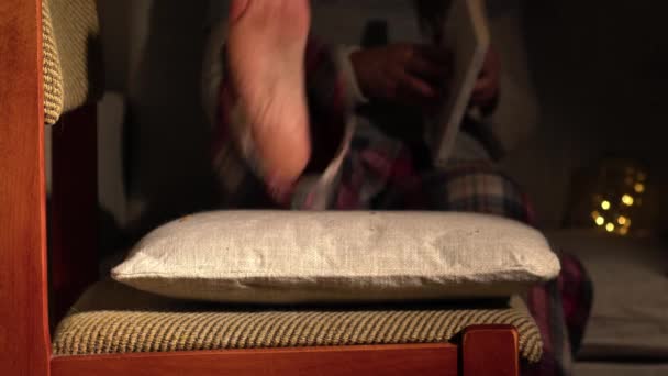 vrouw zet voeten omhoog en ontspant met een boek 4k slow motion selectieve focus  - Video