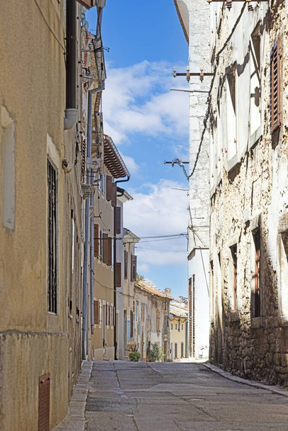 Фото типичной уличной сцены из исторического хорватского города Вознян с мощеными улицами и старыми зданиями в утреннем свете - Фото, изображение