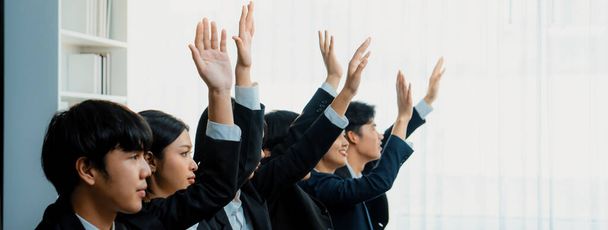 Business team of kantoormedewerkers steken hun hand op in seminar of business workshop training om vragen te stellen. Een groep vrijwillige werknemers die vrijwilligerswerk doen met hun handen omhoog. Slim. - Foto, afbeelding
