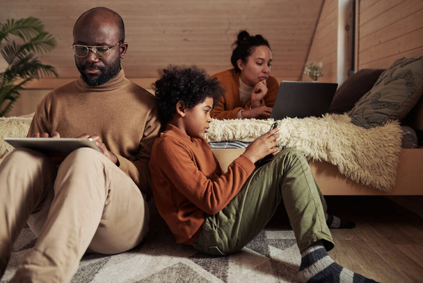 Akıllı telefonu olan tatlı bir çocuk babasının yanında oturmuş tablet kullanıyor ya da internetten bilgi topluyor. - Fotoğraf, Görsel