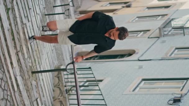 Viajero caminar escaleras de la calle en el viaje de verano vista vertical. Chico guapo explorar la ciudad disfrutando de casas auténticas solo. Turista hispano enfocado paseando por la antigua ciudad de Portugal. Concepto recuerdos de viaje  - Imágenes, Vídeo