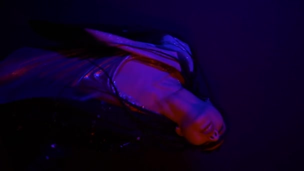 Κατακόρυφο βίντεο της δροσερό νεαρή Ασιάτισσα γυναίκα σε πολύχρωμο κόκκινο μπλε φως, κοιτάζοντας την κάμερα. Αστικό στυλ. Νέα μόδα Hipster τάση - Πλάνα, βίντεο