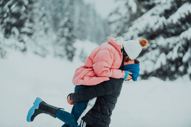 Σε μια χιονισμένη μέρα του Αγίου Βαλεντίνου, αυτό το ρομαντικό ζευγάρι μοιράζεται ζεστασιά, γέλιο και τρυφερές αγκαλιές, δημιουργώντας μια χαρούμενη χειμωνιάτικη ιστορία αγάπης - Φωτογραφία, εικόνα