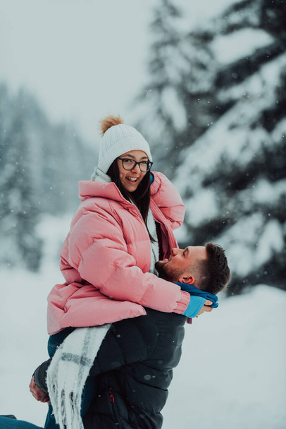 Karlı bir Sevgililer Günü 'nde, bu romantik çift sıcaklığı, kahkahaları ve şefkati paylaşıyor, mutlu bir kış aşk hikayesi yaratıyor. - Fotoğraf, Görsel
