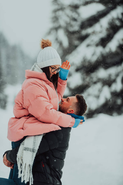 On a snowy Valentines Day, this romantic couple shares warmth, laughter, and tender embraces, creating a blissful winter love story - Photo, Image