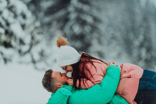 У День святого Валентина ця весела пара створює чарівні спогади, граючи та ділячись сміхом на сніжному тлі, святкуючи любов у зимовій країні чудес..  - Фото, зображення