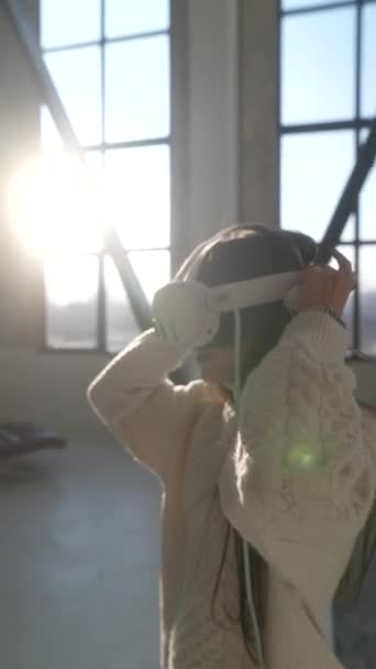 Dans son décor familial, une superbe jeune fille s'engage dans un jeu virtuel à l'aide de lunettes 3D VR. Images 4k de haute qualité - Séquence, vidéo