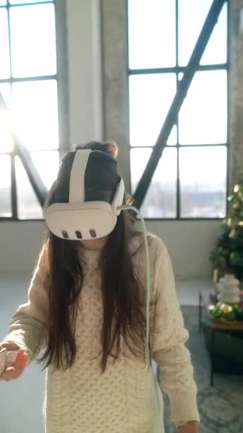 Egy élénk fiatal nő játszik egy dinamikus online játék egy virtuális valóság headset. Kiváló minőségű 4k felvételek - Felvétel, videó