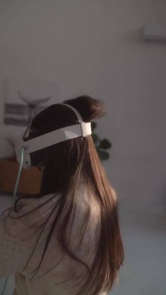 Met behulp van een virtual reality headset, een dynamisch jong meisje speelt actieve online games. Hoge kwaliteit 4k beeldmateriaal - Video