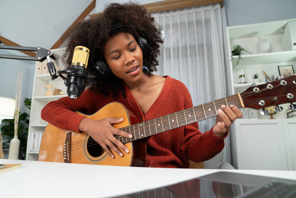 若いアフリカ系アメリカ人のミュージシャンのホストチャンネルと歌い,スタジオでラップトップで放送. ヘッドセットの装置の装飾および記録マイクロフォン. トーストメーカー. - 写真・画像