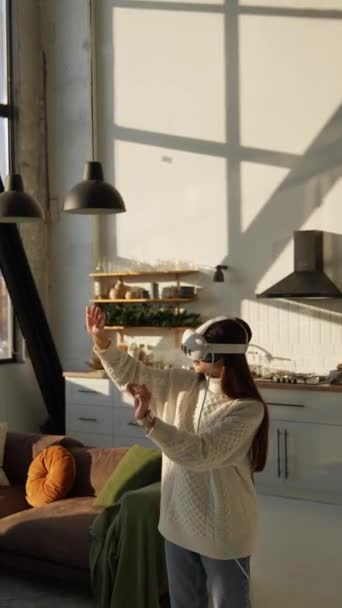 Una joven encantadora que lleva un casco de realidad virtual con un árbol de Navidad a la vista. Imágenes de alta calidad 4k - Metraje, vídeo