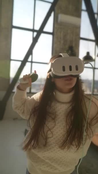 Met behulp van een virtual reality headset, een levendige jonge dame dompelt zich onder in actieve online games. Hoge kwaliteit 4k beeldmateriaal - Video
