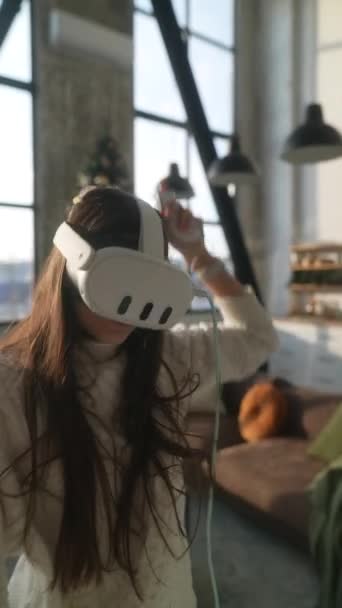 Eine lebhafte junge Frau, die in aktives Online-Gaming vertieft ist, bedient sich eines Virtual-Reality-Headsets. Hochwertiges 4k Filmmaterial - Filmmaterial, Video