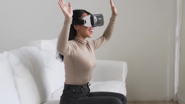 Νεαρή γυναίκα που χρησιμοποιεί εικονική πραγματικότητα VR goggle στο σπίτι για κρίσιμη εμπειρία online αγορών. Η καινοτομία εικονικής πραγματικότητας VR βελτιστοποιημένη για τον γυναικείο τρόπο ζωής ψηφιακής ψυχαγωγίας. - Πλάνα, βίντεο