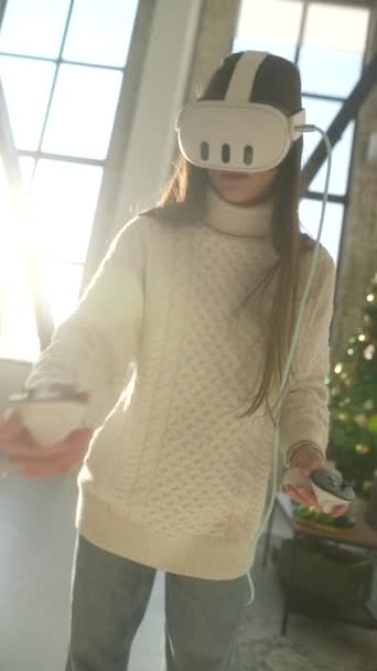 Playing an online virtual game, a young woman wears a virtual reality headset. High quality 4k footage - Footage, Video