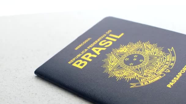 Бразильський паспорт на білій поверхні, що представляє національну ідентичність простим і елегантним способом. - Кадри, відео