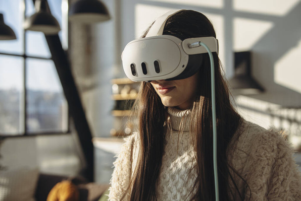Eine aufgeweckte junge Frau begrüßt den sonnigen Tag mit einem Virtual-Reality-Headset. Hochwertiges Foto - Foto, Bild