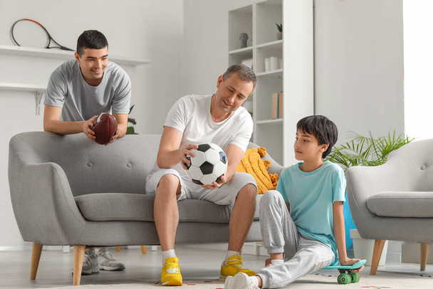 Niño deportivo con su padre y su abuelo en casa - Foto, imagen